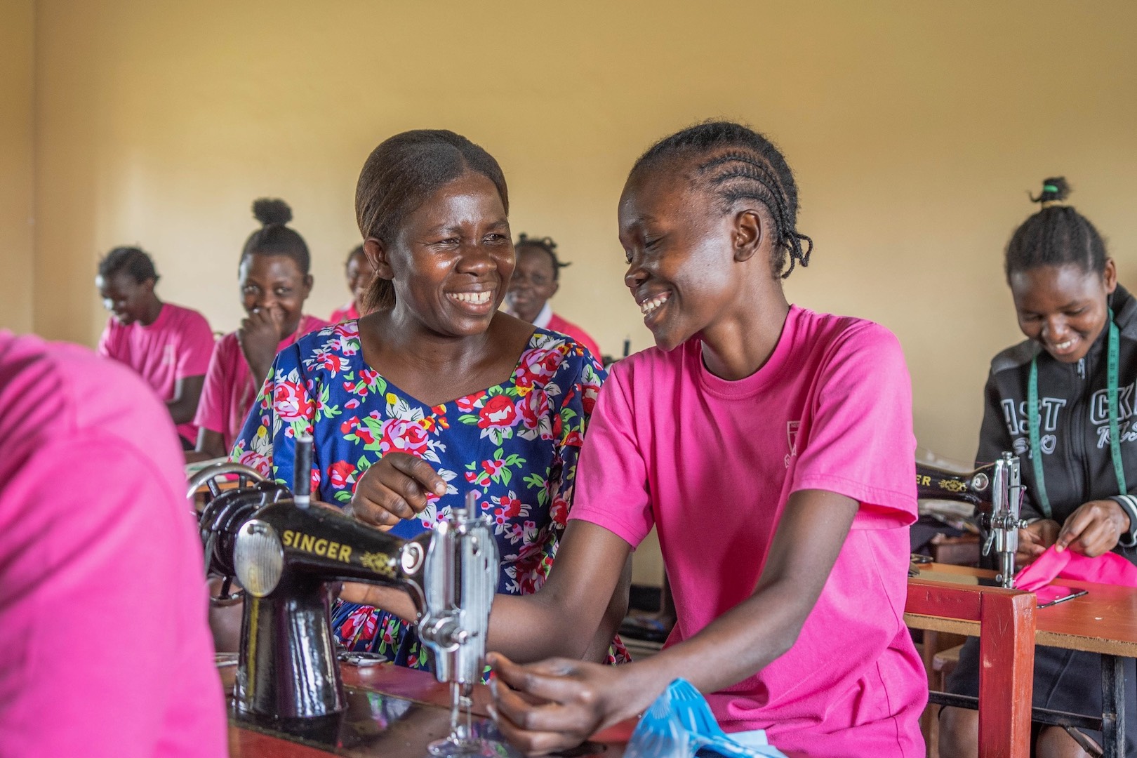 Eunice%20smiling%20with%20students%20tailoring